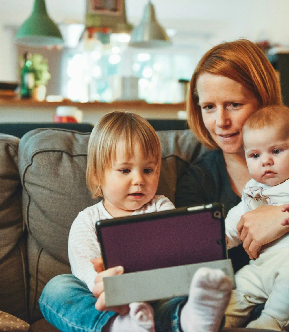 Mother relaxing on the couch with her two young children